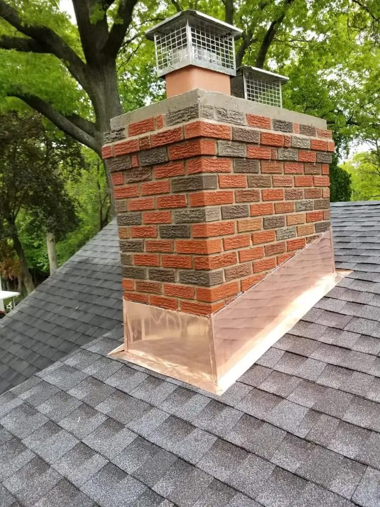 Brick chimney with new copper flashing and a stainless chimney cap