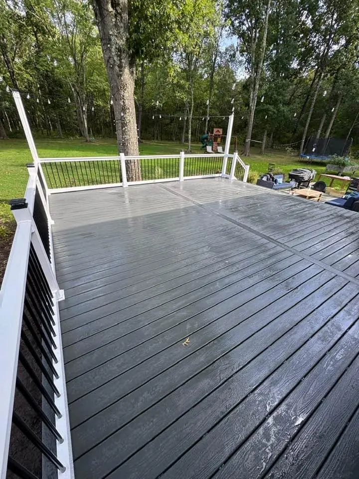 Composite deck with white posts and black balusters overlooking a lawn