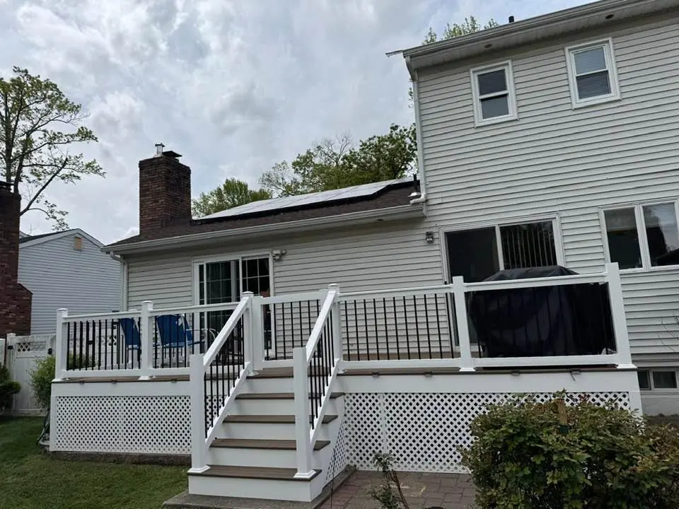 Composite deck with white railings, lattice skirt and stairs to the yard