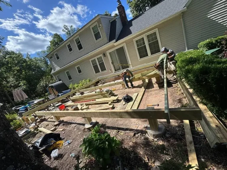 New deck framing on footings beside a two-story home