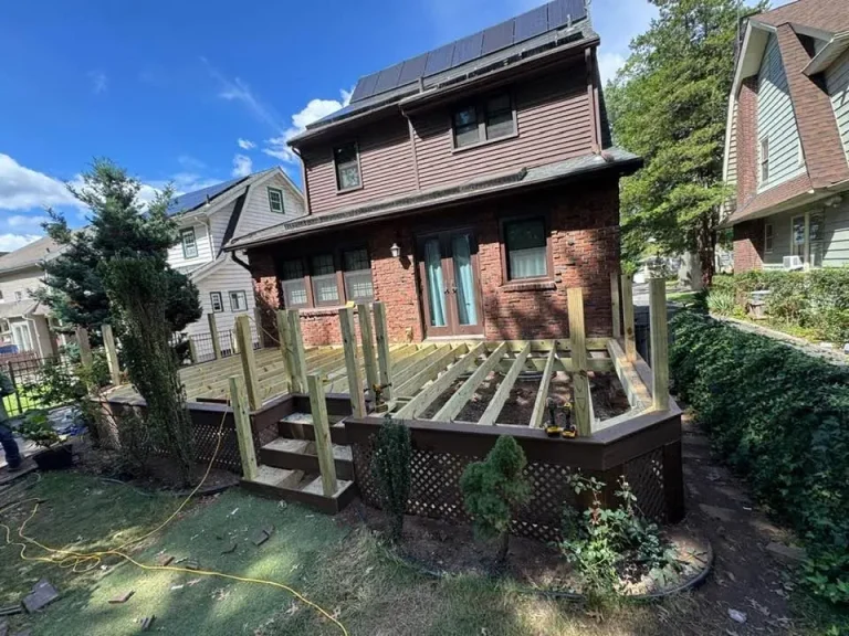 Deck rebuild framing behind a brick house