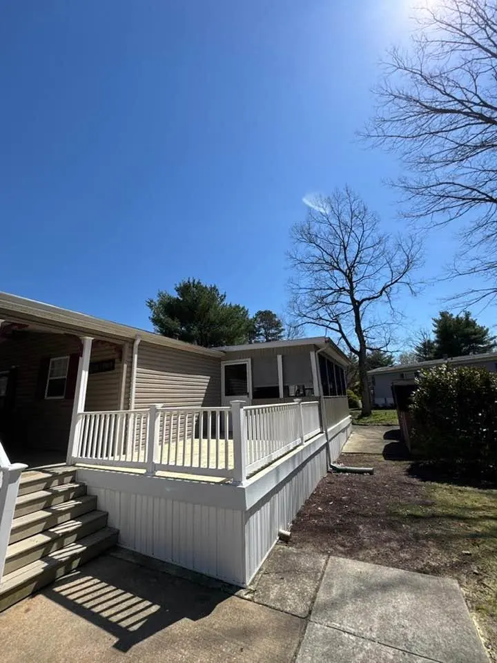 Deck with white vinyl skirting, railings and stairs