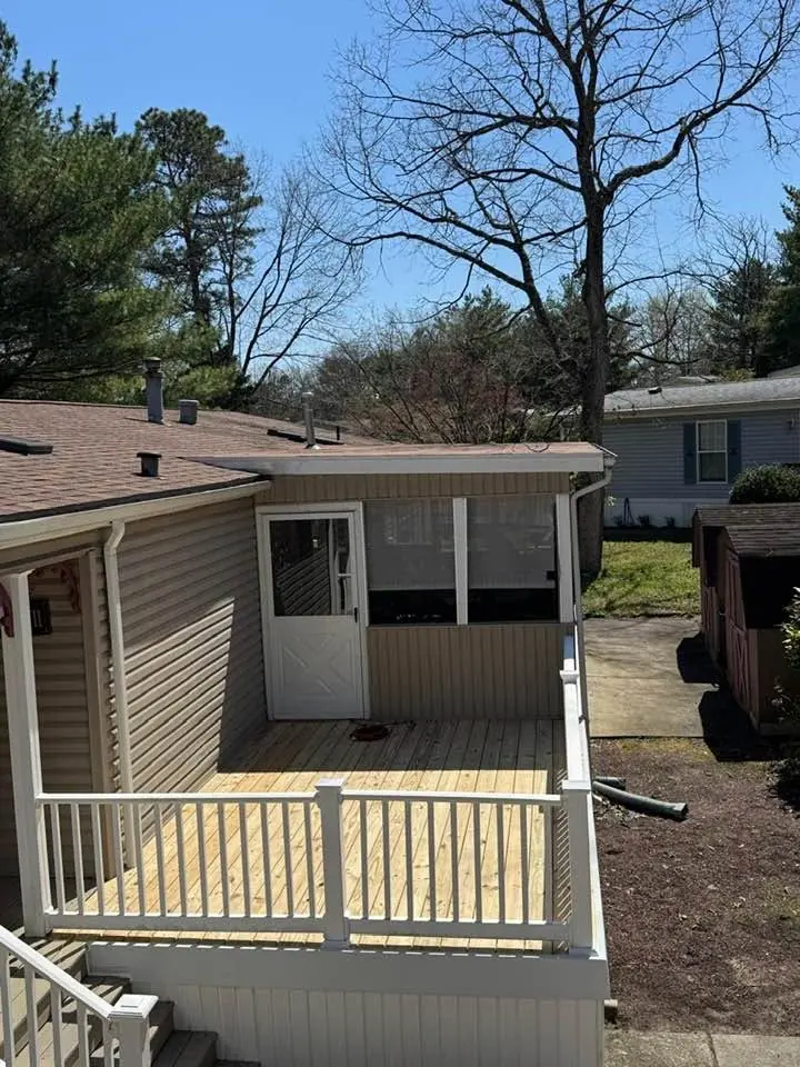 New backyard deck with white railings and a door to the house