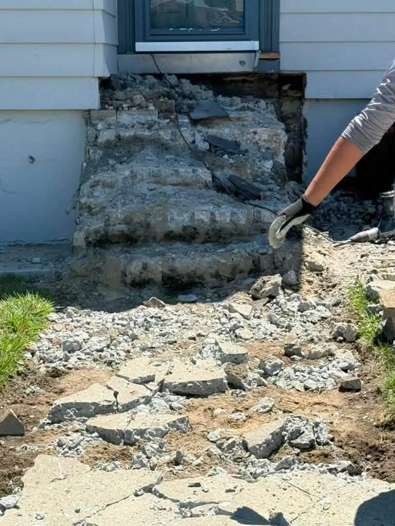 Old crumbling concrete steps being broken out before a rebuild